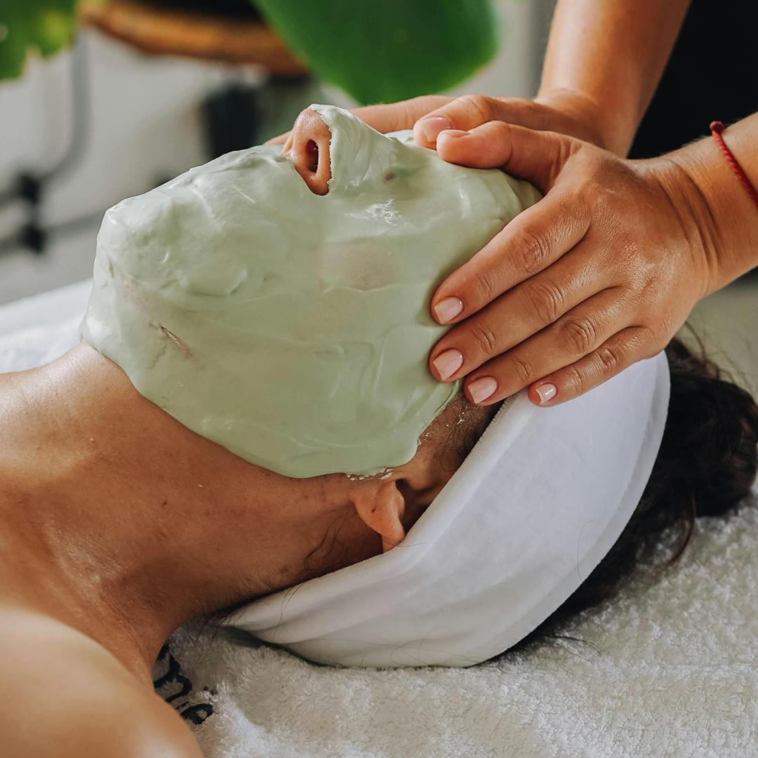 Woman receiving a rejuvenating facial mask treatment at SolRae Wellness Spa, a holistic skincare spa in Grand Rapids specializing in personalized facials and natural skin treatments.