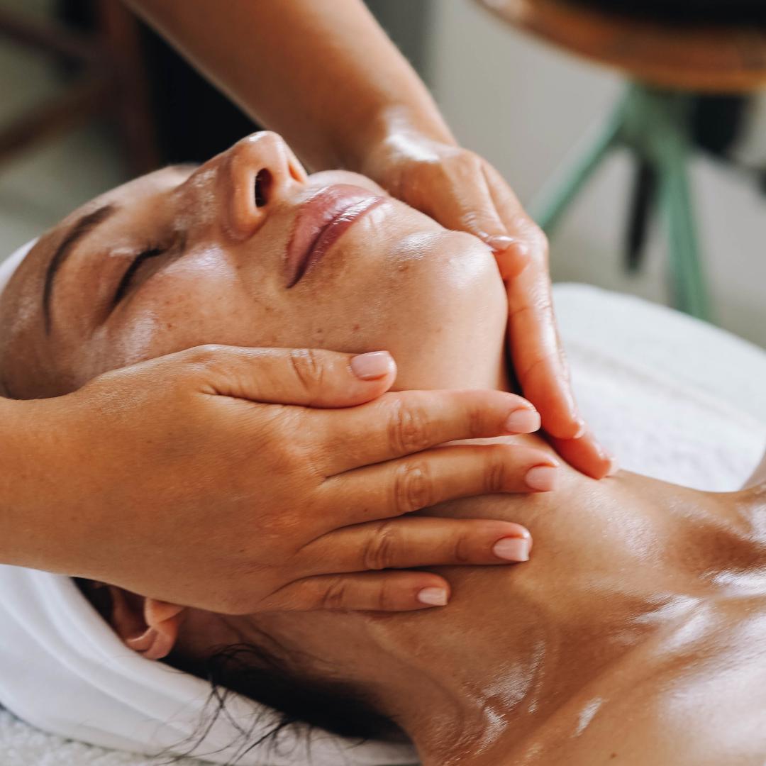 Relaxing scene of a woman receiving a facial treatment at a wellness spa, highlighting luminous skin and the soothing atmosphere of holistic skincare.