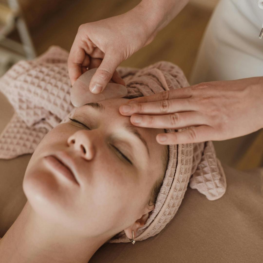 Woman enjoying a rejuvenating Gua Sha facial at SolRae Wellness Spa, highlighting the soothing technique that enhances skin radiance and promotes relaxation.